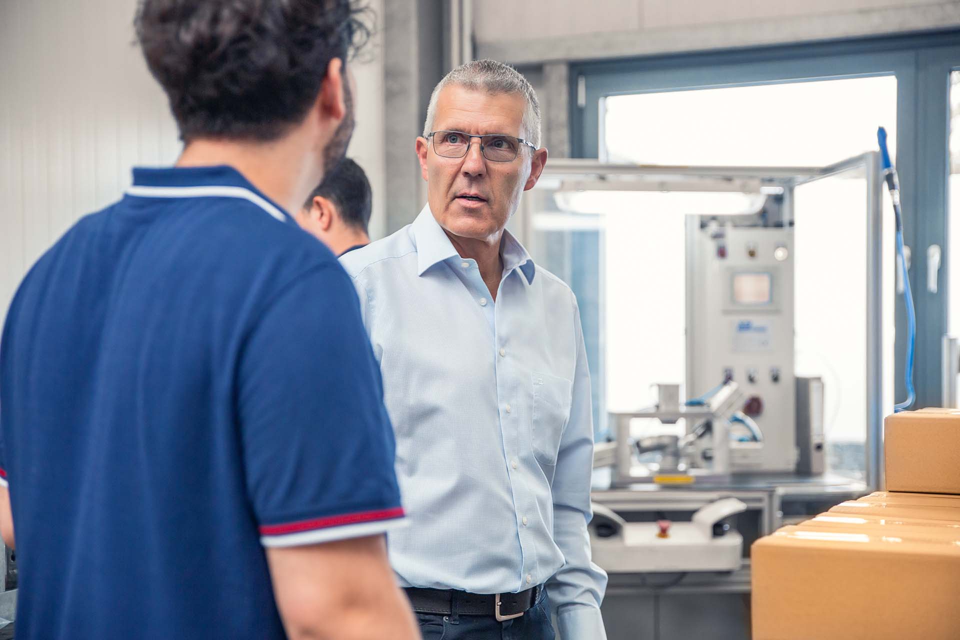 Michael Schlüter im Gespräch mit einem Mitarbeiter in der Fertigung